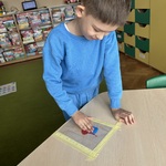 Chłopiec wykonuje eksperyment _Taniec kolorowych świateł_.jpeg