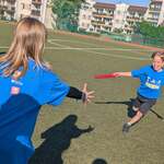 13. Dzieci przekazuja pałeczkę w czasie biegu sztafetowego.jpg