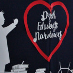 Zdjęcie 1. Napis Dzień Edukacji Narodowej na tle szkolnej scenografii.JPG