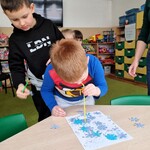 2 Chłopcy zdejmują za pomocą słomek papierowe śnieżynki_ które zakrywają obrazek...jpg