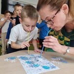 4 Pani i uczeń_ za pomocą słomek_  odkrywają obrazek przykryty papierowymi śnieżynkami..jpg
