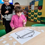 11 Dziewczynka przenosi za pomocą słomki  małe obrazki na duży obrazek z garnkiem..jpg