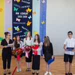 Prowadząca uroczystość z przedstawicielami uczniów klas ósmych i siódmych.jpg