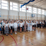 Ucznennice_ uczniowie wraz z nauczyciealmi śpiewają wspólnie hymn Polski.jpg