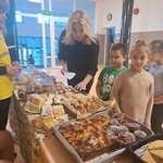 Pani Dyrektor oraz mali uczestnicy kiermaszu wybierają słodkości..jpg