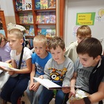 Dzieci z zainteresowaniem czytają książki.jpg