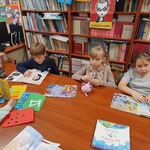 Dzieci przeglądają ksiązki dostęne w bibliotece.jpg