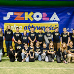 Zdjęcie 1 Grupa uczniów i nauczycieli ustawieni w dwuszeregu na tle banneru..jpg