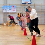 8 Dzieci i rodzice biegną trzymając między głowami krążek.jpg