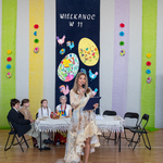 3 Pani Patrycja Borys rozpoczyna uroczystość. Stoi na scenie uśmiechnięta i opowiada o zwyczajach wielkanocnych i wiośnie.jpg