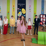 13.Dziewczynka- Eliza Strzałkowska ubrana w kolorową sukienkę w kwiaty śpiewa piosenkę __Alleluja__.Aktorzy stoją za nią..jpg