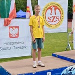 chłopiec zdobywca srebrnego medalu w biegu na 600 m na podium.jpg