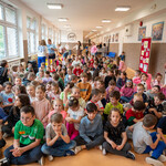 Zdjęcie nr 3. Uczniowie klas 1-3 gromadzą się na szkolnym holu.jpg