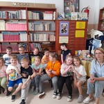 4. Dzieci przedszkolne wraz z wychowawczynią - p. Sylwią na tle książek..jpg